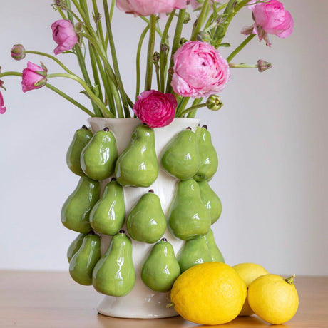 Green pear vase with pink flowers and lemons by Noss and Co